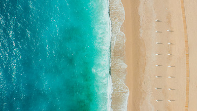 在土耳其的Oludeniz，打着遮阳伞的梦幻般的绿松石海滩鸟瞰图