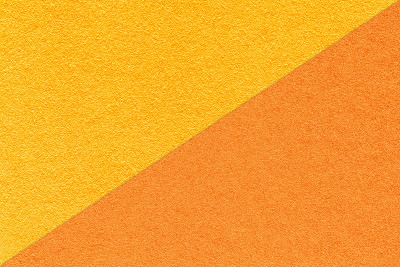工艺质感明黄和橘色的纸张底色，一半两色，微距。纸板的结构。