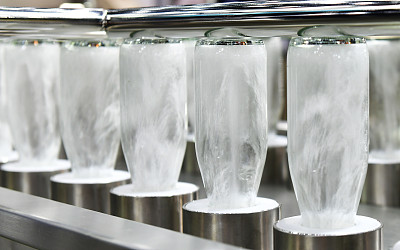 在生产自动化机器上用热水清洗正在加工中的饮料瓶、玻璃瓶