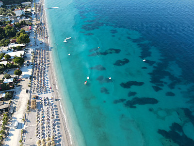无人机拍摄的阿尔巴尼亚爱奥尼亚海岸的夏季海滩度假胜地的雨伞，罗施