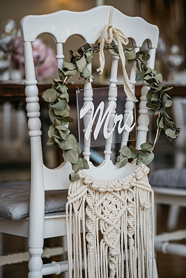 White wooden chair for bride with macramé at romantic table setting