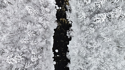 加拿大魁北克，暴风雪后冬季北方自然森林和河流的鸟瞰图