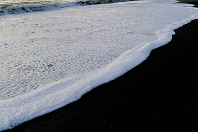 白色的海浪和黑色的沙滩