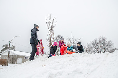 孩子和父母在雪地上滑行