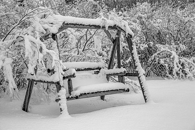 被雪覆盖的花园秋千凳