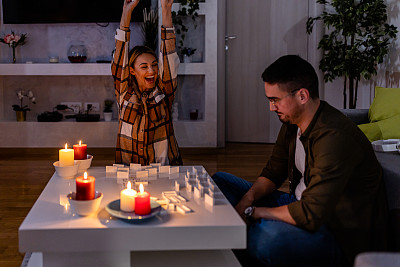 一个男人和一个女人在能量危机的停电时间玩多米诺骨牌。