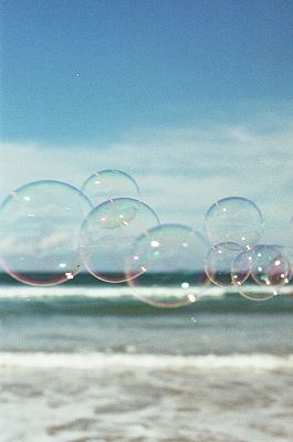 垂直的美丽透明的肥皂泡与泡沫的海浪在模糊的背景