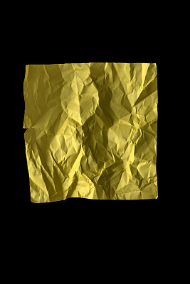 黑色底色的黄色皱纸。纹理、背景