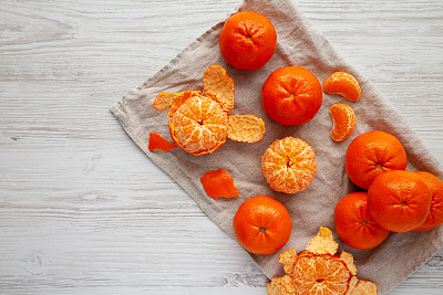 Raw Organic Mandarin Oranges on a white wooden background, top view. Flat lay, overhead, from above. Copy space.