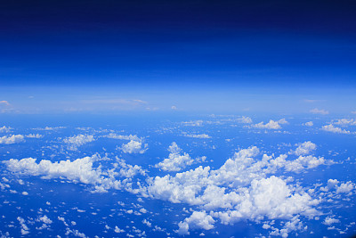 Cloudscape背景。从飞机的窗户往外看。白云蓝天，浓淡不一。