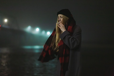 金发女子在夜街抽烟。孤独的