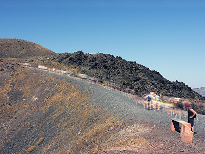 徒步旅行者正在爬上火山