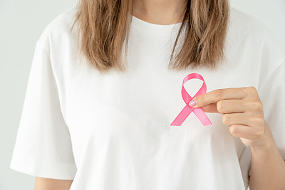妇女手持粉红丝带提高乳腺癌意识。女性健康检查意识。国际妇女节和世界癌症日。象征癌症，象征保健，支持患者，及时诊断