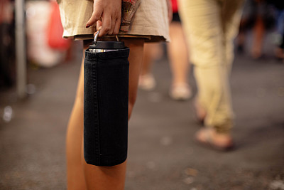 独自旅行的女孩在街上携带的水瓶杯，用于可持续旅行