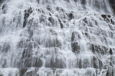 Dynjandi瀑布水纹理。冰岛美丽纯净的大自然。强大的山河背景。巨大的水流，无限的自然能量。欧洲旅行。去哪儿都可以。高质量的照片。