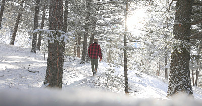 成熟的男人走在雪山小路上