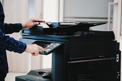 复印打印机，近身办公人员按下面板上的复印按钮，即可使用复印机或影印机扫描文件，打印一张纸。