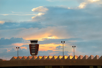 现代机场的空中交通管制或ATC塔，被认为是空中交通的神经中心，背景是令人惊叹的日落天空。