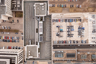 无人机拍摄的摩天大楼屋顶和停车场附近的摩天大楼在春季阴天。