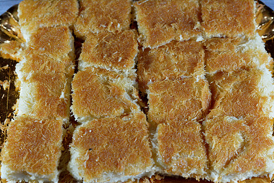 传统的中东甜点Knafeh Konafa由旋转的糕点卡塔伊菲制成，浸泡在甜糖蜜糖浆中，分层加入奶酪，凝固或打发的奶油，埃及斋月库纳法甜点