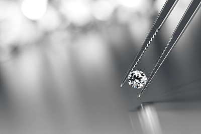 辉煌的水晶钻石和镊子上的黑色背景与对象软聚焦3d渲染
