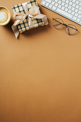 父亲节快乐的概念。垂直横幅模板与节日礼盒，咖啡杯，键盘，眼镜在棕色背景顶部视图。
