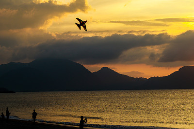 日落时海上天空放风筝