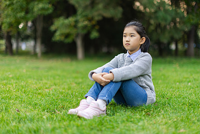 小女孩坐在草地上