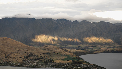 鸟瞰新西兰云层下的岩石悬崖和乡村山谷