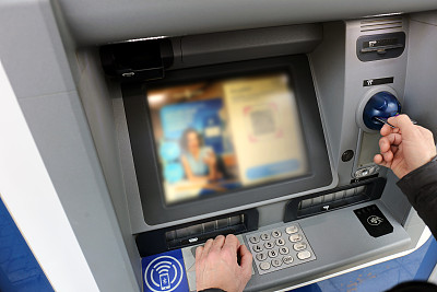 一名男子在自动取款机上用信用卡进行交易