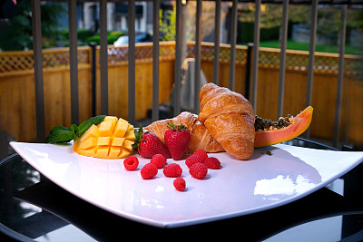 美丽美味的甜点在阳台上巨大的方形白色盘子热带副食水果牛角面包传统的法国午餐早餐美味的服务美丽的食物服务空间文字广告