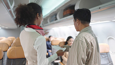 女空乘人员检查乘客登机牌，欢迎乘客登机。女乘务员在飞机上向乘客打招呼。航空公司的概念