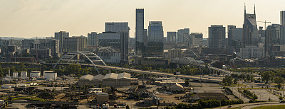 田纳西州纳什维尔市中心的天际线，摩天大楼和公路桥在夕阳的照耀下映衬着戏剧性的天空。鸟瞰图