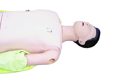 医院急诊室地板上的救护车训练假人，训练胸部按压的假人，隔离在白色背景上