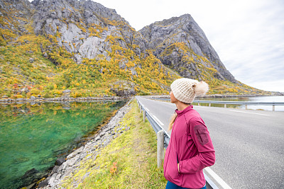 女人在秋天旅行，她沿着路边、湖边走