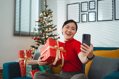 亚洲女性喜欢在圣诞节用智能手机打视频电话或直播视频视频。