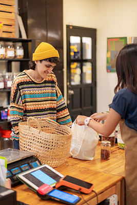 年轻的中东人在零废物商店用可重复使用的袋子购物