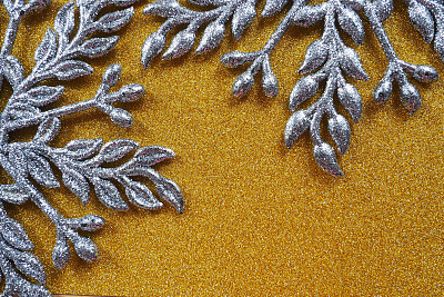两个大的银平华丽的雪花被放置在天鹅绒般的金纸上。文本的自由空间。新年或圣诞节背景广告。喜庆的冬天平躺。黄色和灰色背景。