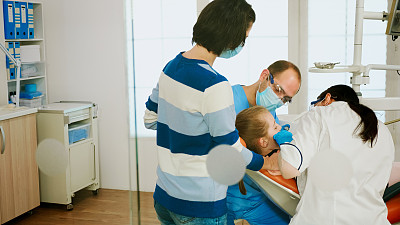 牙科医生为孩子清洁牙齿，治疗牙齿问题