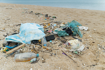 海岸线上的海滩上有各种塑料垃圾，这些垃圾是由人类活动和废物处理不当造成的。海滩上的塑料污染是一个日益严重的环境问题，影响着海洋生物和生态系统。