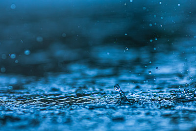 雨滴落在水坑里。下雨了。溅起的水