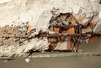 拆除的一堵砖墙用锈迹斑斑的铁棒，抽象化纹理近距离呈现
