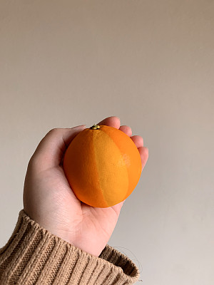 充满活力的佛罗里达橙色加上浅色的楔形，让它看起来像2024年冬天女人手中的沙滩球