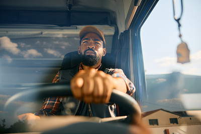 非裔美国司机驾驶卡车的特写。