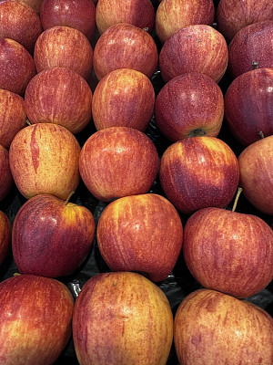 新鲜农产品市场的全画幅图像，一排排成熟的红色皇家Gala苹果(Malus domestica 'Royal Gala')在塑料箱中，高架视图