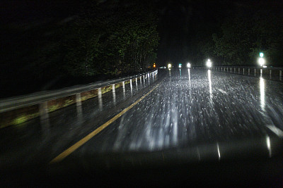 黑夜丘陵弯曲高速公路在暴雨期间