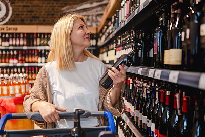 成年女性在杂货店买酒