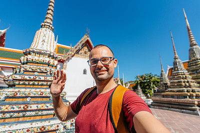 在泰国曼谷卧佛寺，一名年轻人正在进行视频通话