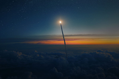 黄昏时分，带着爆炸和烟雾的航天飞机穿过云层进入星空。宇宙飞船成功地从地球发射到外太空。火箭发射，概念