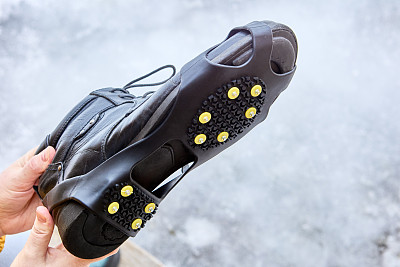 防滑铆钉胶鞋穿在鞋底，以防止打滑和提供更好的牵引力。